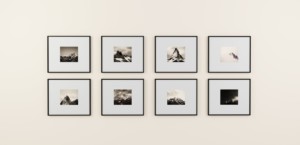 A gallery wall of black and white photos hanging against a white background