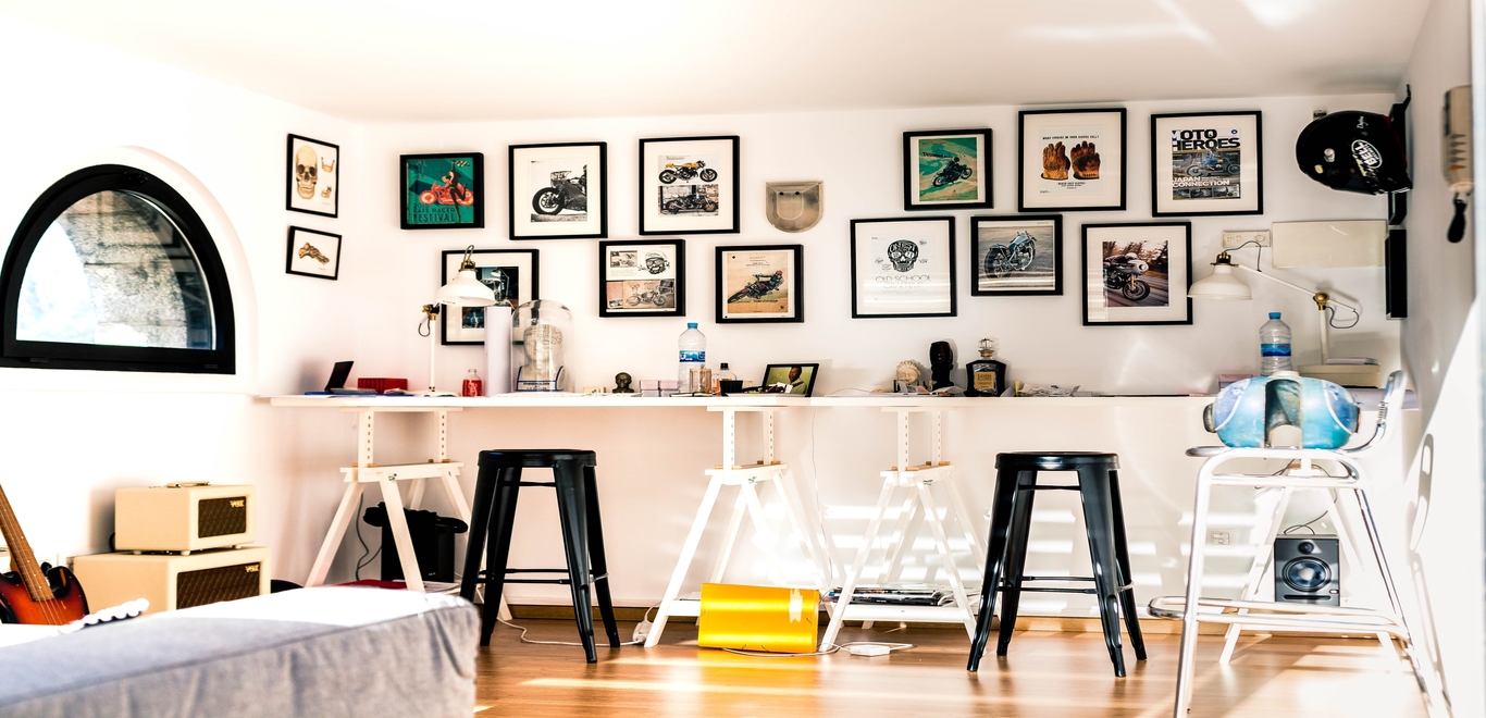 An assortment of artwork hanging gallery wall-style above a long table