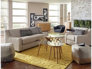 Inviting living room featuring grey couches, yellow rug, wooden coffee table with decoration