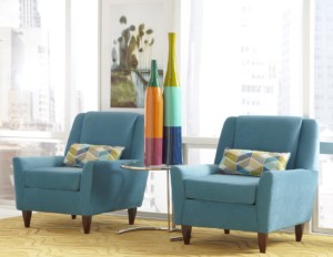 Bright living room turquoise arm chairs, tall and colorful table accents in front of a window with natural light, overlooking a city