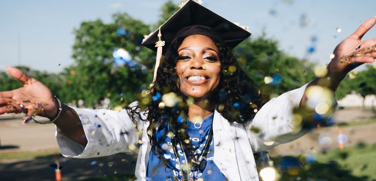 woman in graduation cap throwing confetti