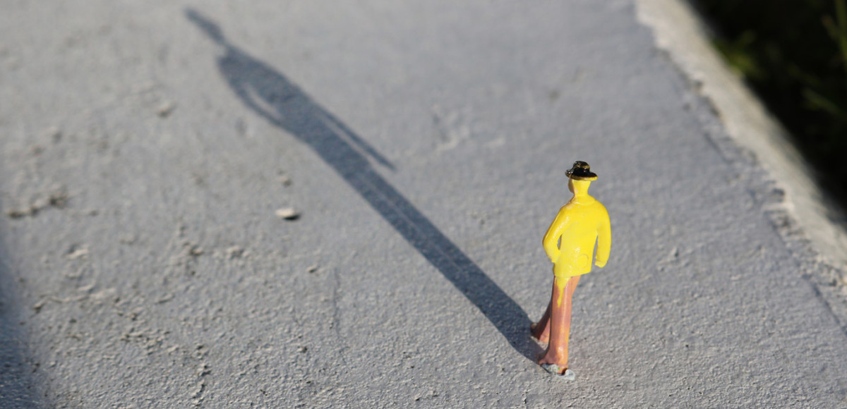 Small figurine of a man walking with a shadow