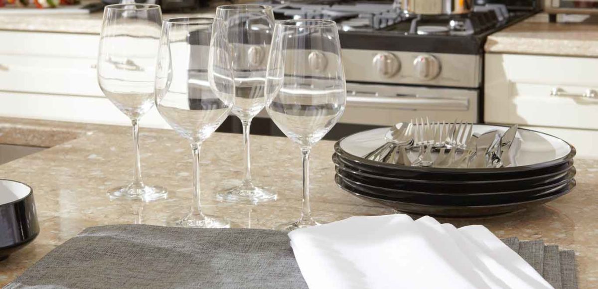 Wine glasses, plates and silverware on a kitchen counter