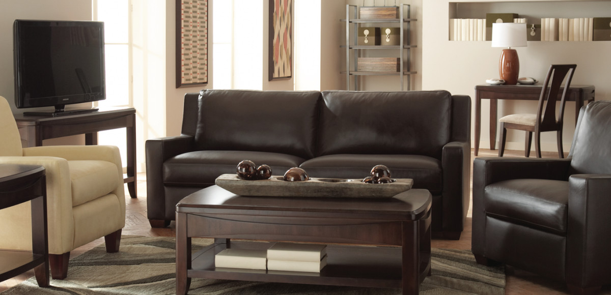 Living room with leather sofa, leather chair and creme chair with a coffee table in the middle.