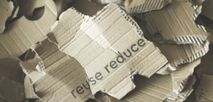 Cardboard fragments with reduce and recycle printed on brown cardboard
