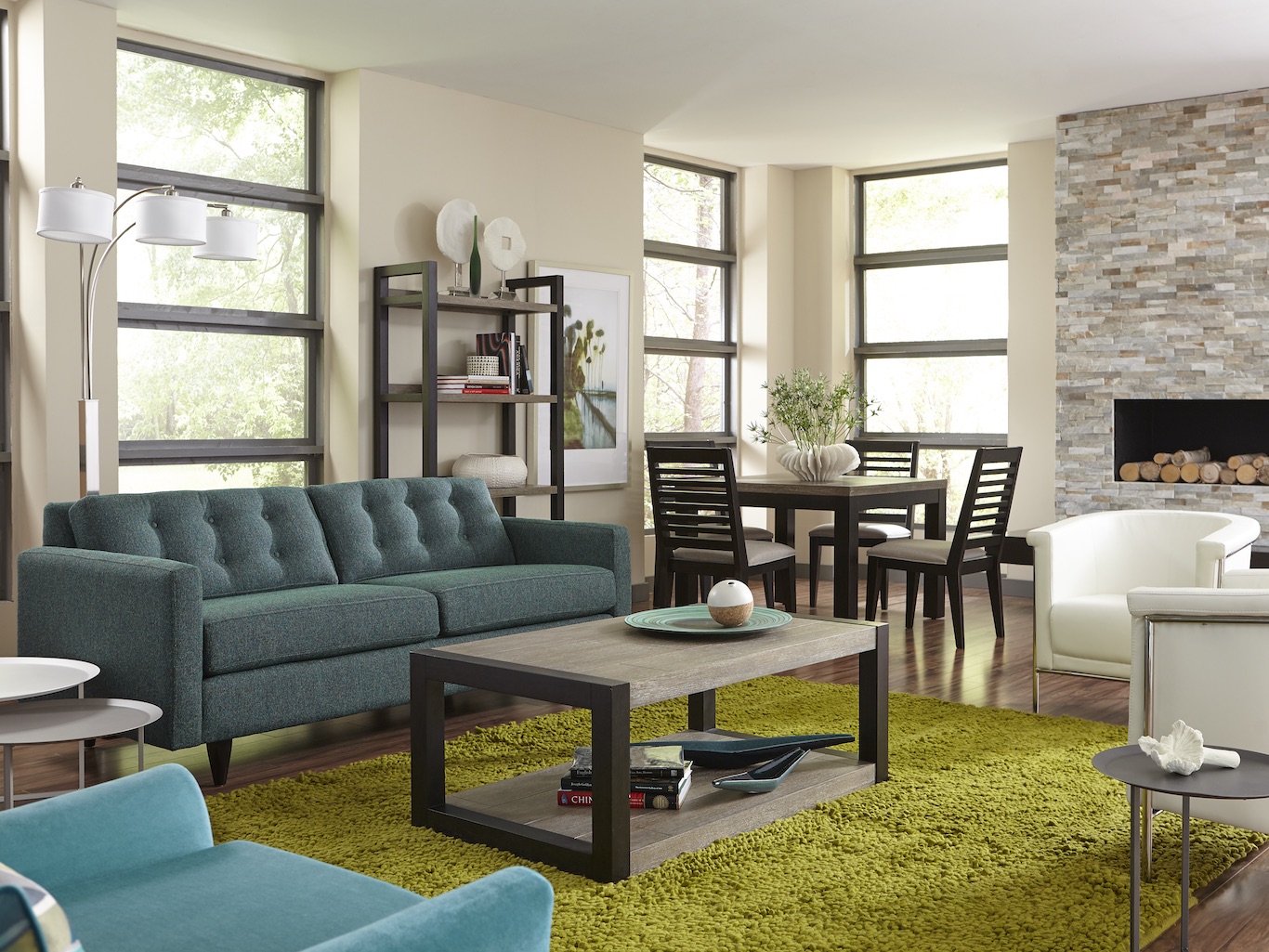 Living room with visible dining room, featuring a blue couch, green carpet, wooden coffee table