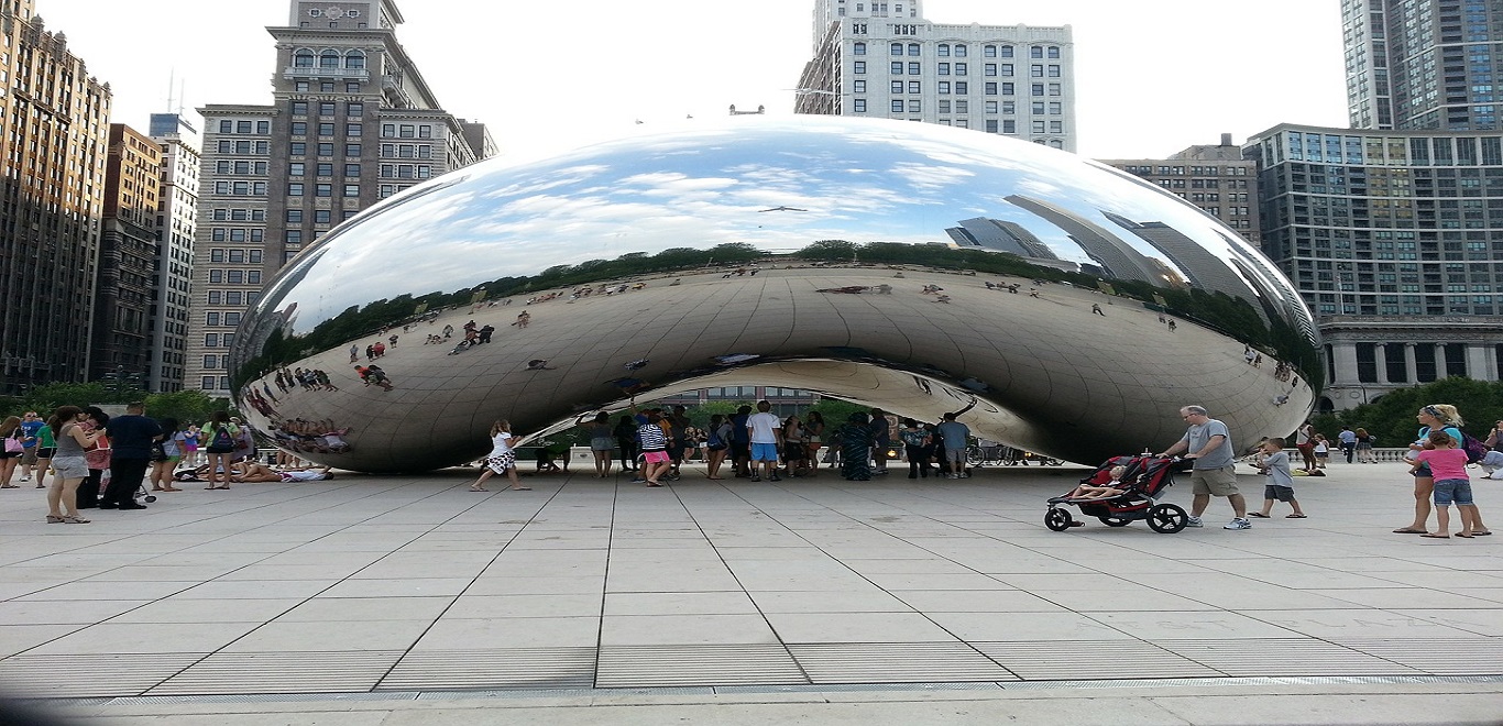 Locals and tourists admiring Cloud Gate (The Bean), a sculpture in downtown Chicago
