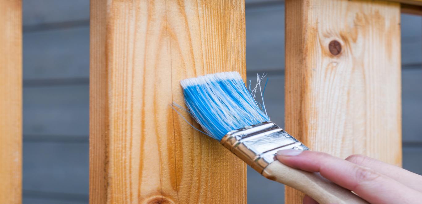 Person using a paintbrush for repainting patio furniture