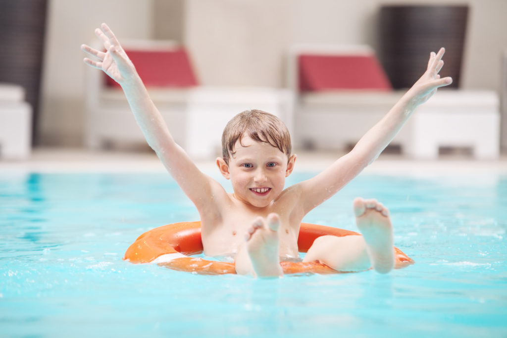 Little boy sitting in a pool in a float