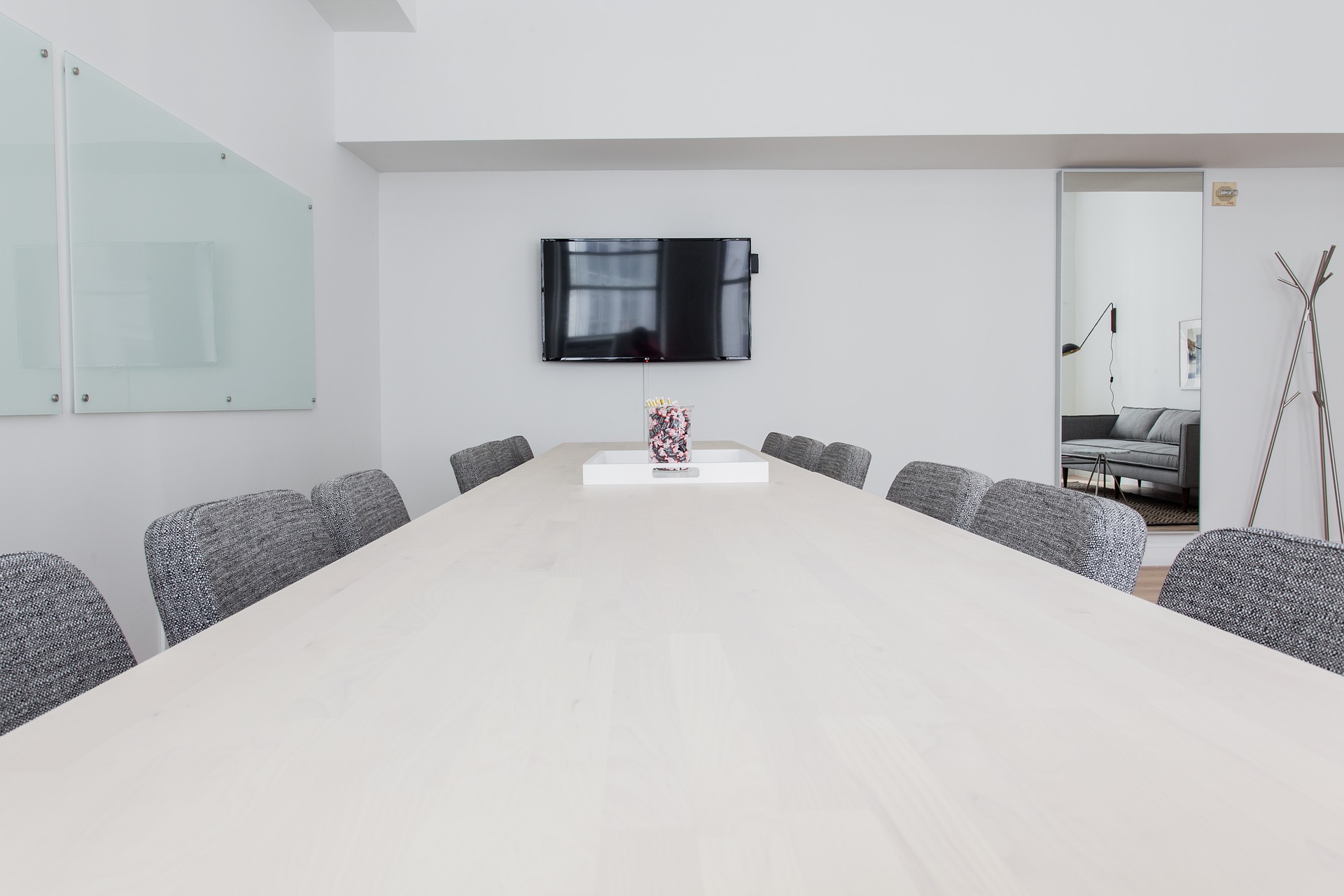 A meeting room with gray fabric chairs, a large conference table, and metal décor