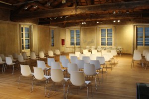 A collection of white, modern chairs arranged in an empty room for an event