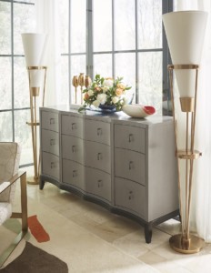 Bedroom featuring grey dresser with floral arrangement and gold floor lamps