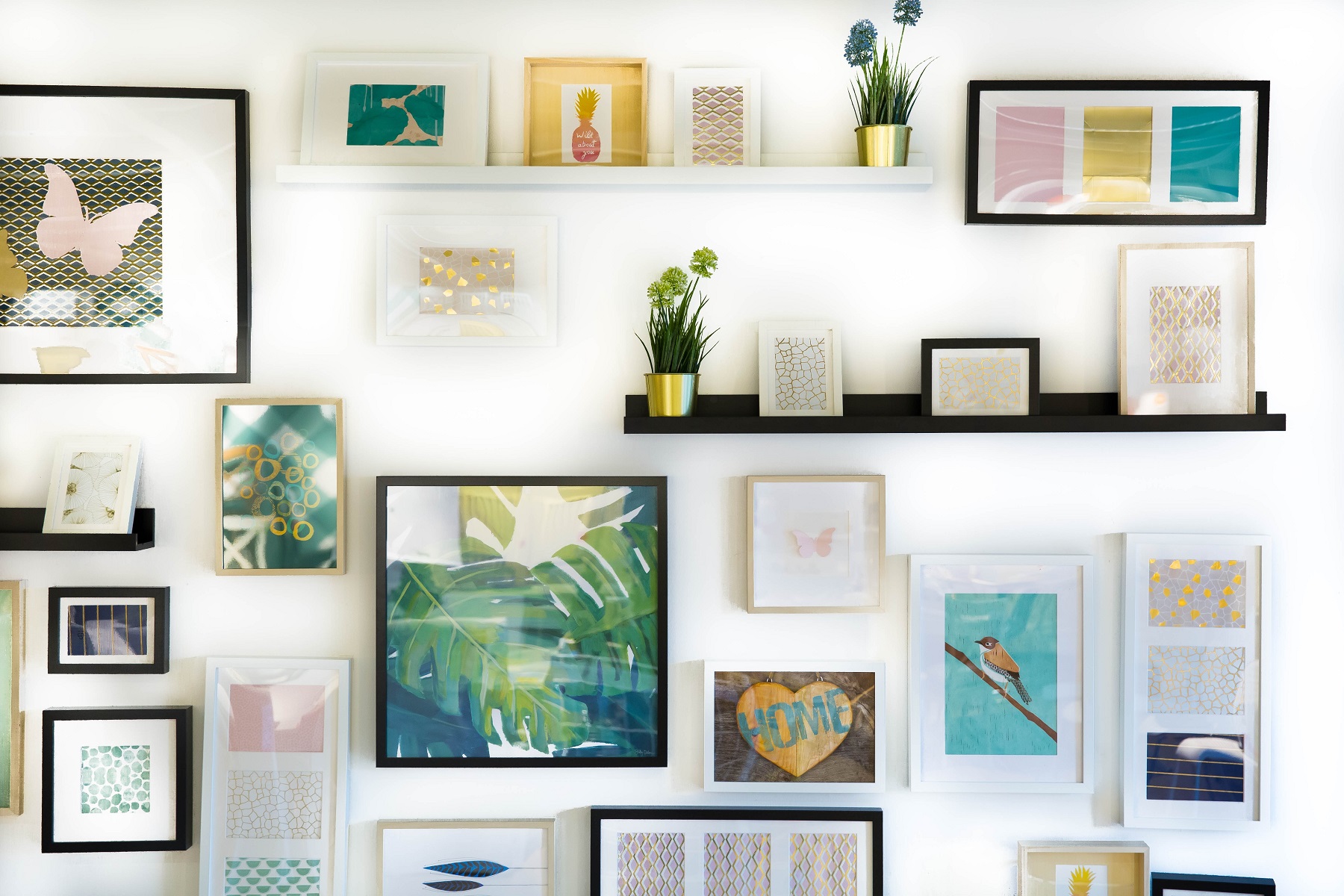 Gallery wall in home office, featuring a mirror, artwork, and notecards