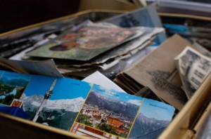 A messy box filled with art and travel mementos