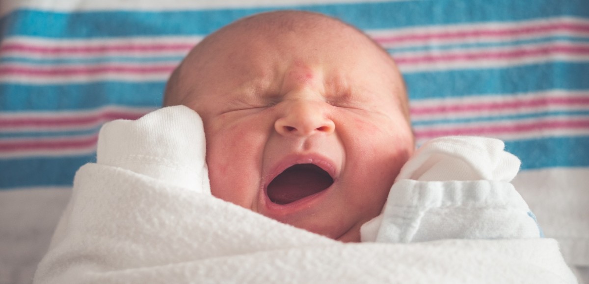 Swaddled and crying newborn baby