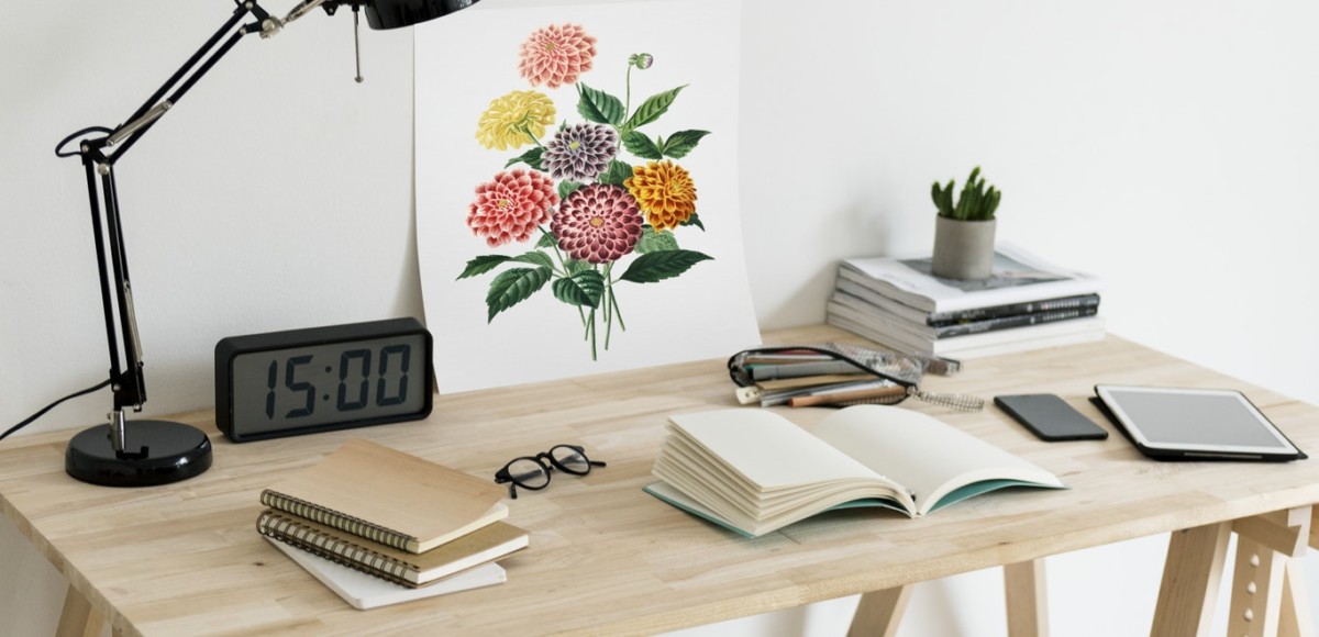 Desk with lamp, clock, notebook, art print
