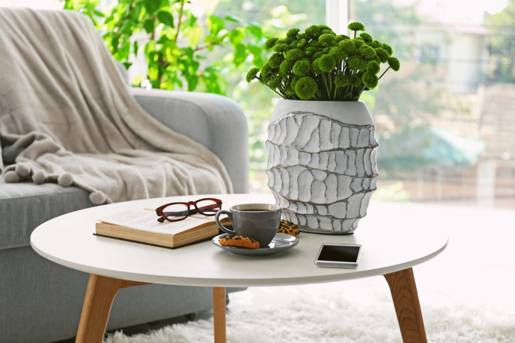 Coffee table with decor on top and a chair in the background