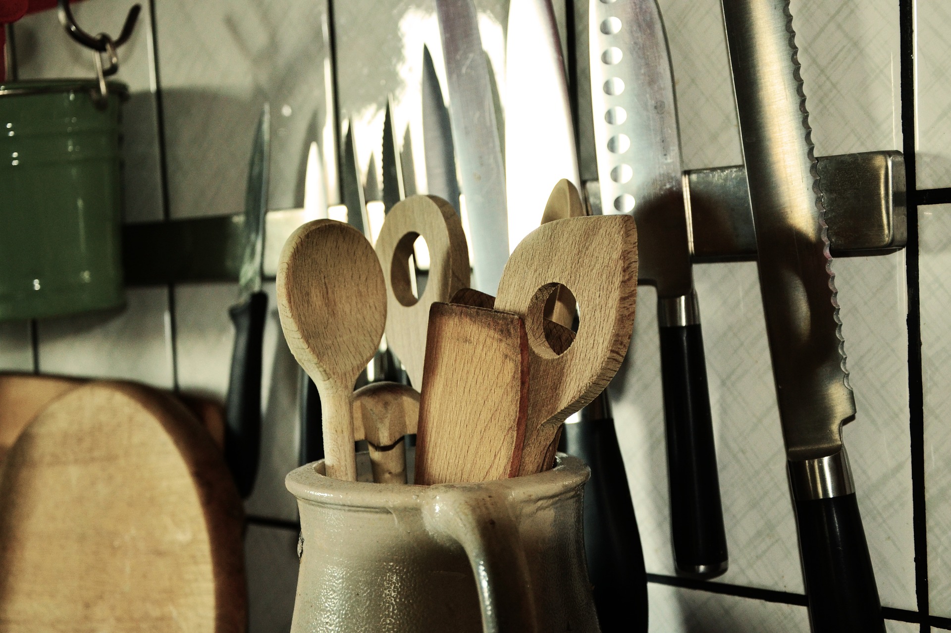 Kitchen utensils, including a canister with wooden spoons and sharp kitchen knives