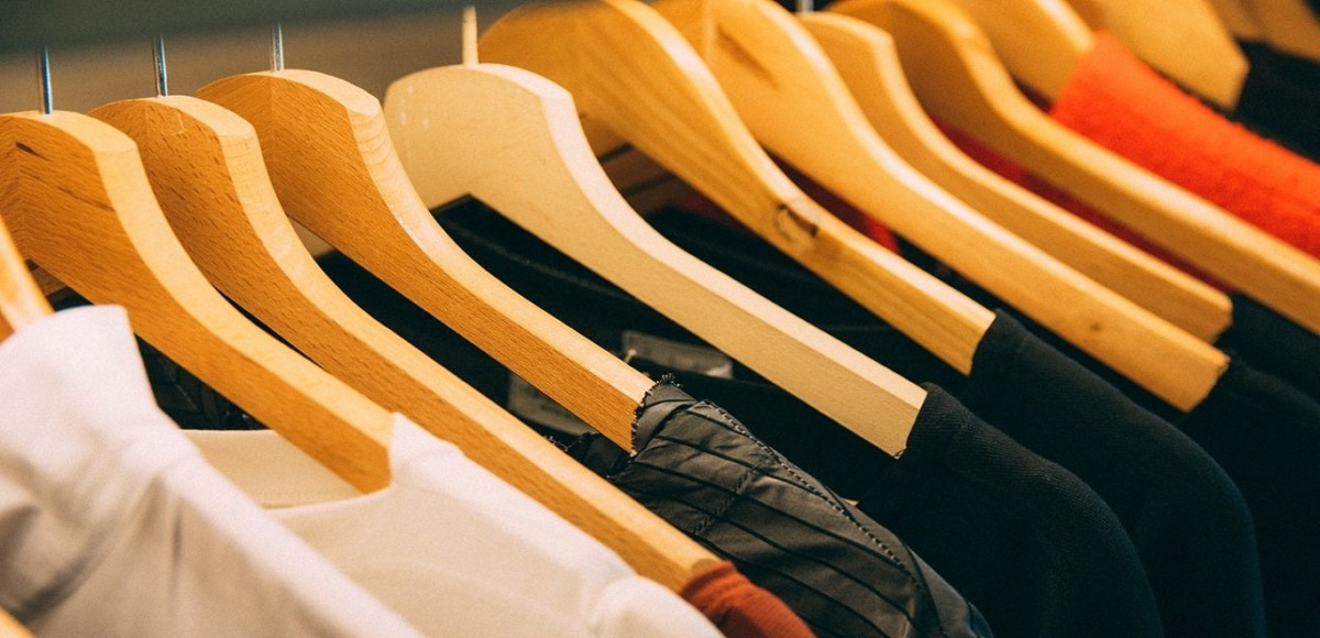 Clothing in a closet on wooden hangers