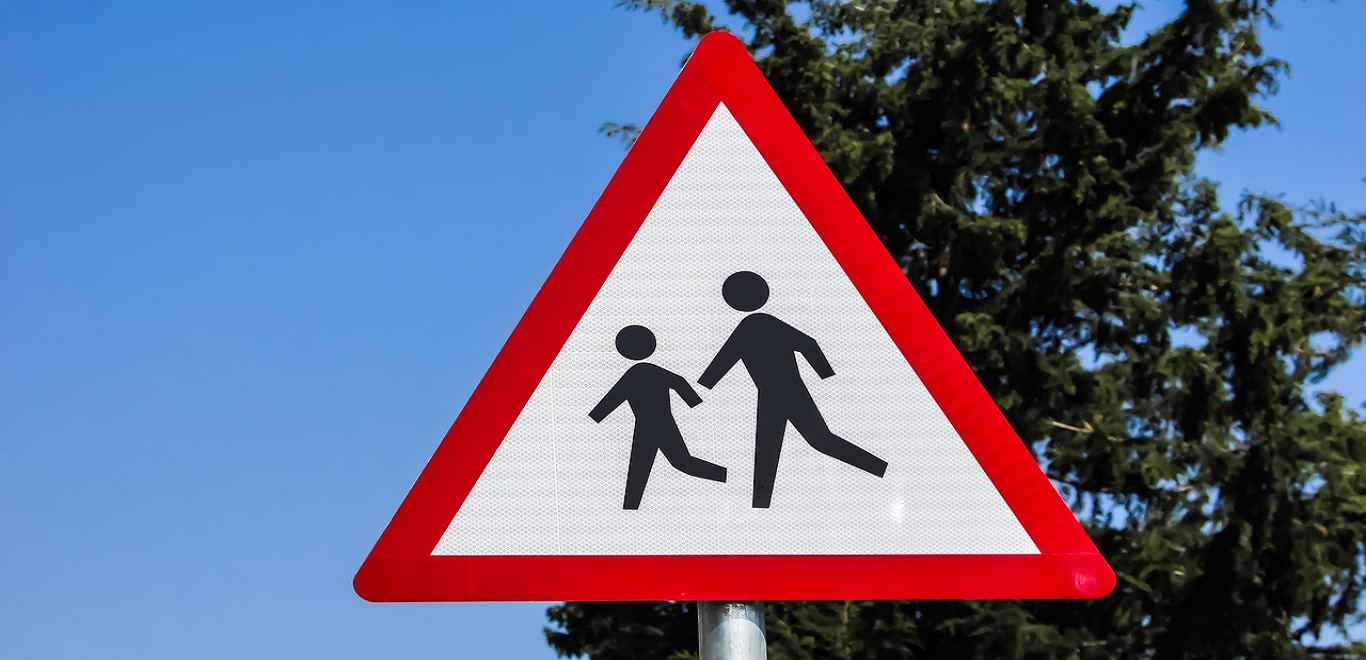 Close-up of a school crossing sign on a sunny day