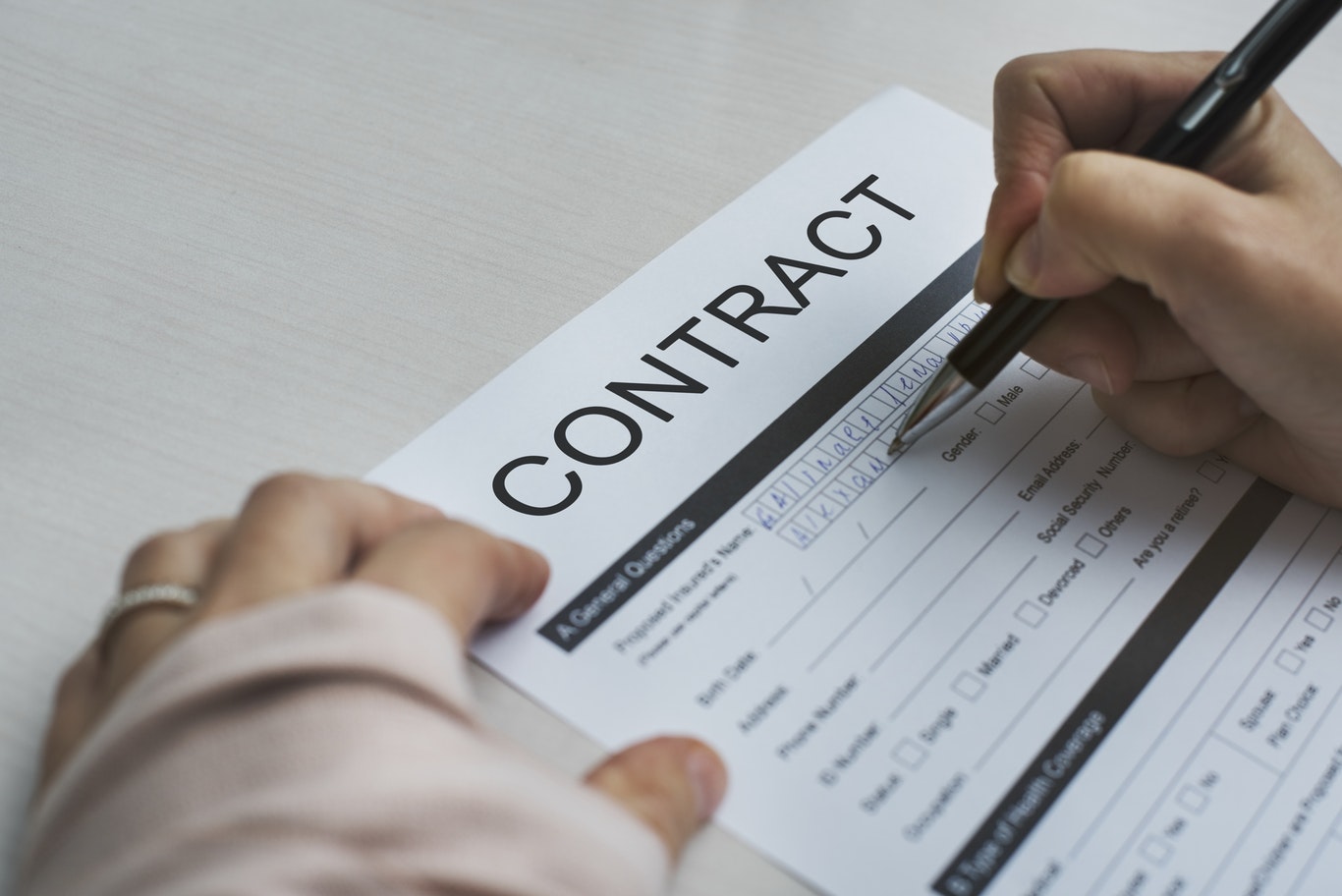 Person filling out a contract
