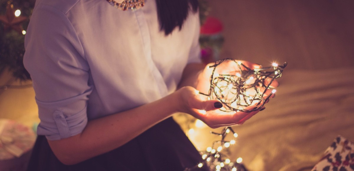 Woman holding string of Christmas lights