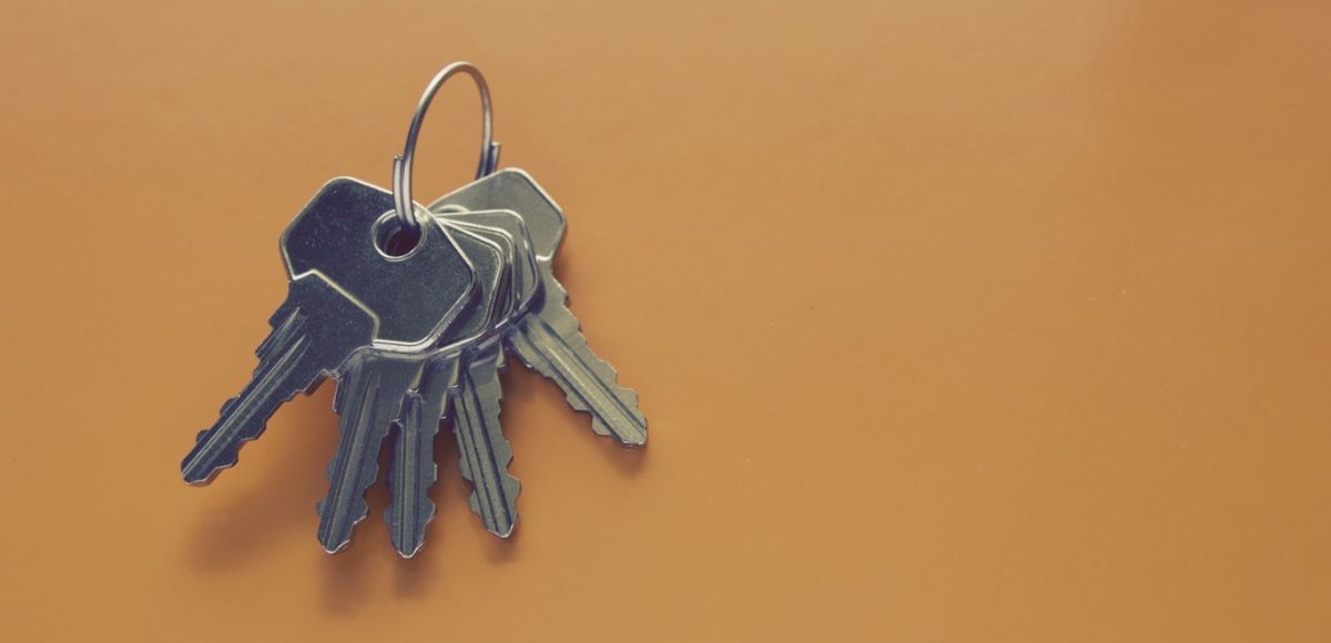 Five metal keys on a ring with an orange background