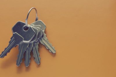 Five metal keys on a ring with an orange background