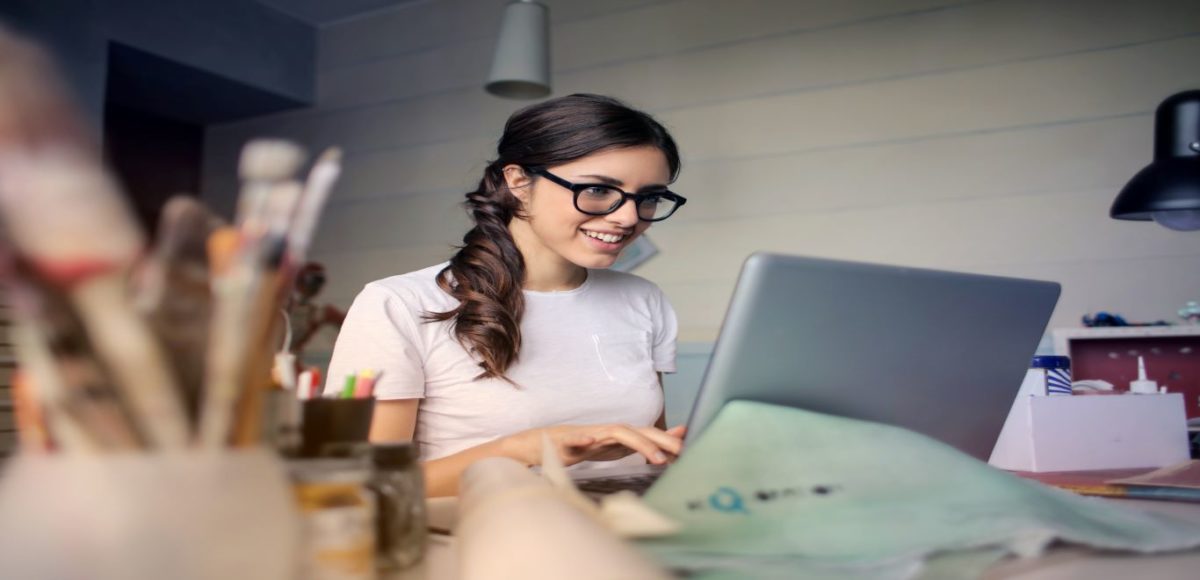 Young woman wearing glasses working on a laptop in her home