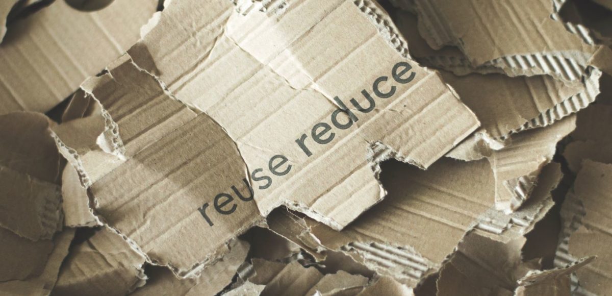 Torn pieces of a cardboard box with the words "reuse" and "reduce" printed on them