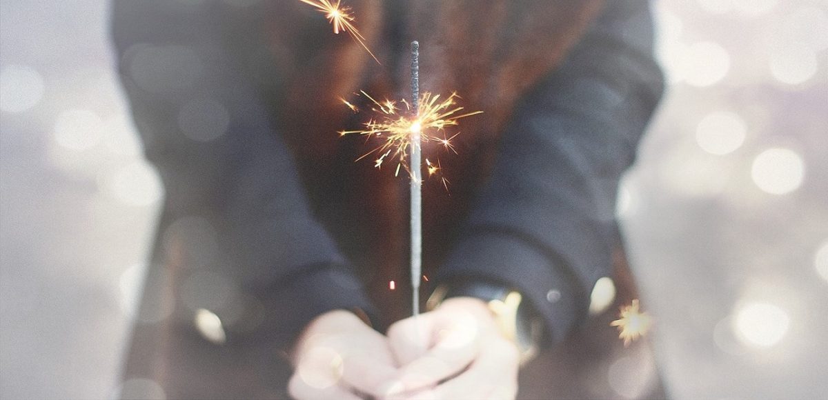 Girl holding a sparkler with a muted background