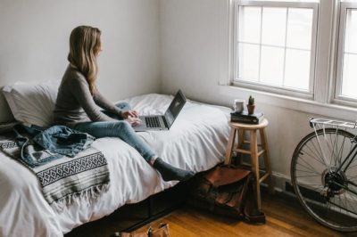 Woman on computer sitting on bed