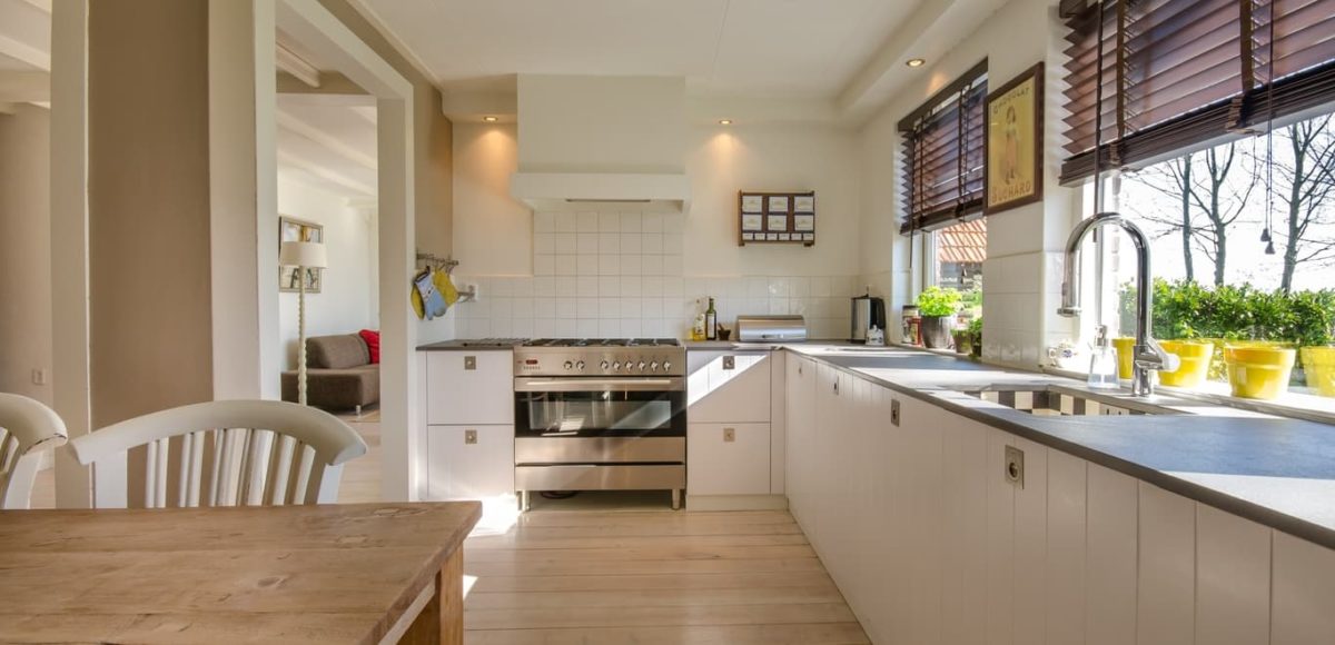 Kitchen without people with bright sunlight coming through window.
