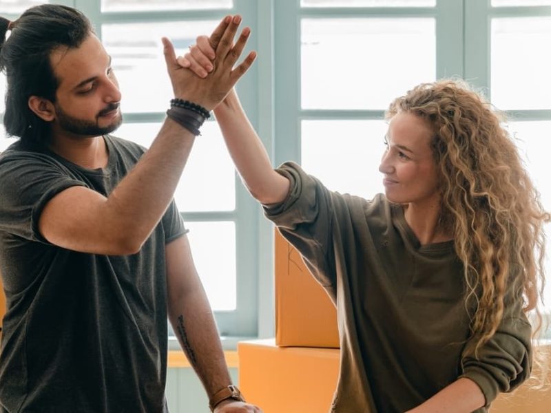 Couple high-fiving in room with boxes