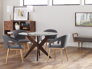 Modern nordic inspired furniture, small round table surrounded by gray chairs with light wood legs.