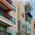 Modern luxury urban apartment building exterior with blue sky.