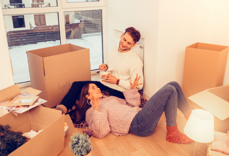 Couple moving into home unpacking and relaxing after moving during the holidays