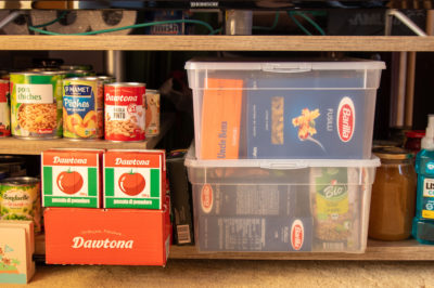 Apartment prepper disaster relief kit in case of emergency containing non-perishable food and first-aid items.