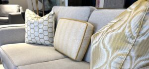 Grey sofa styled for spring with yellow and cream colored pillows