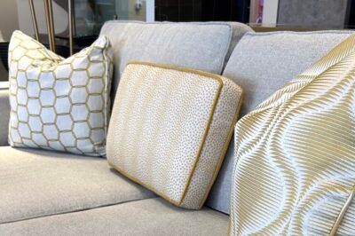 Grey sofa styled for spring with yellow and cream colored pillows