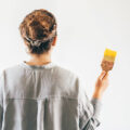 A woman preparing to paint a blank wall yellow.