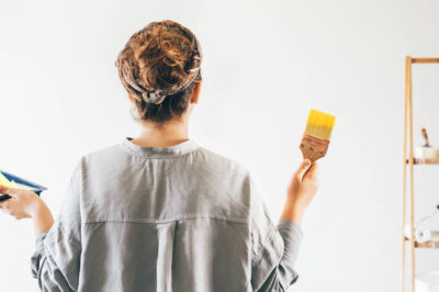 A woman preparing to paint a blank wall yellow.
