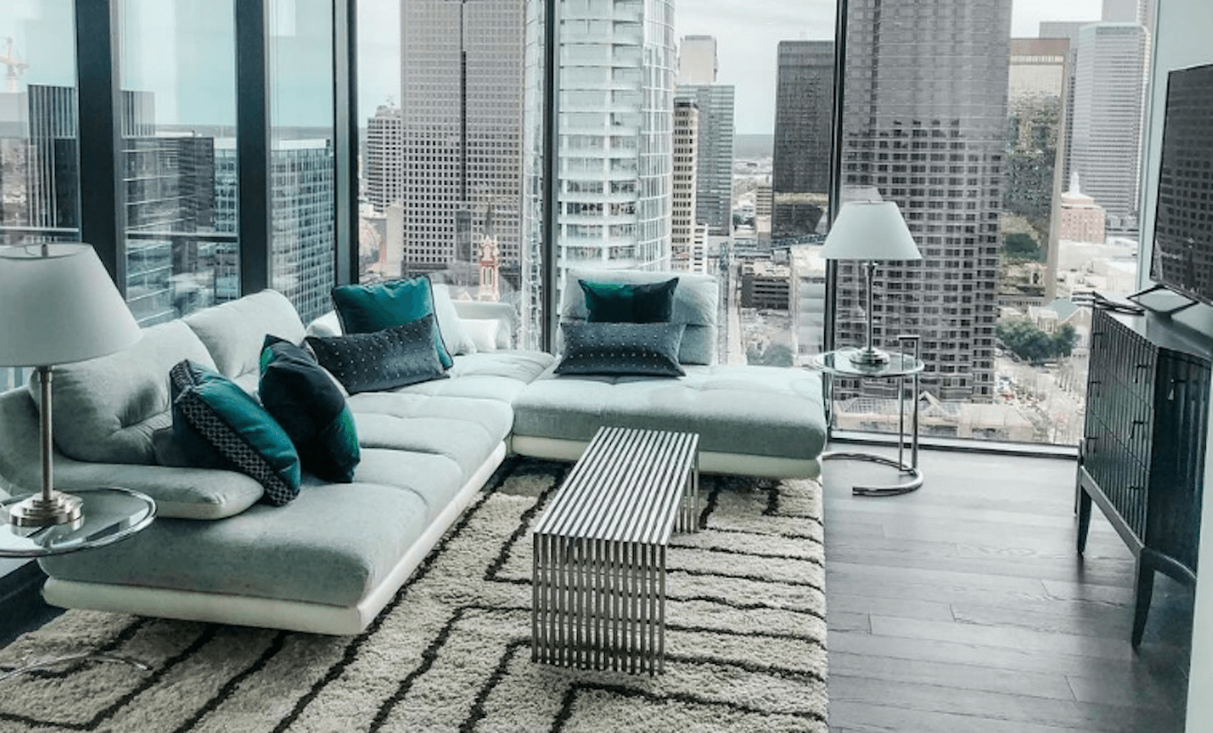 A modern apartment with a city view and a large area rug.