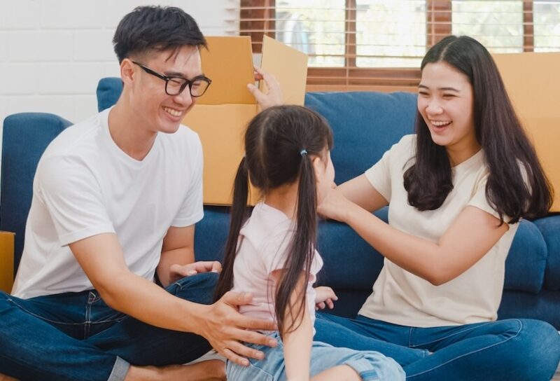 A young family surrounded by moving boxes.