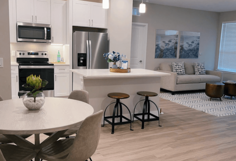 A stylish, open floor plan apartment kitchen and living room.