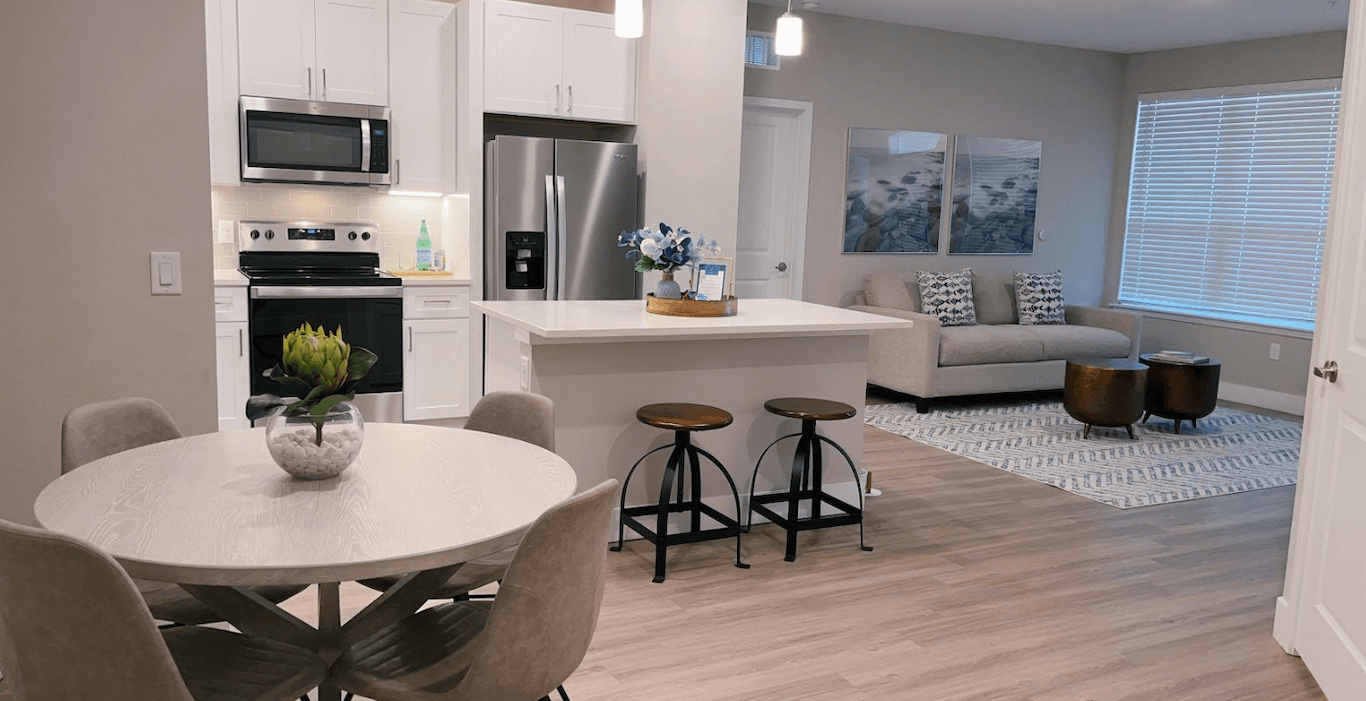 A stylish, open floor plan apartment kitchen and living room.