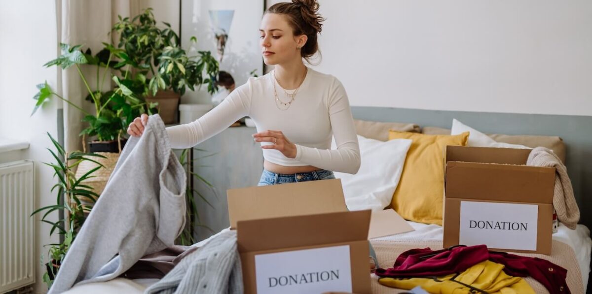 A woman sorting clothes into boxes labeled "donation".