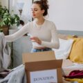 A woman sorting clothes into boxes labeled 