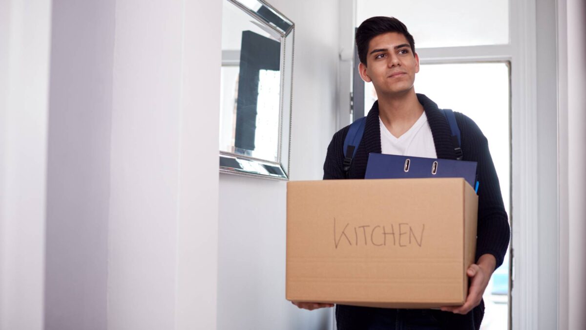 Male college student walking into off campus college apartment