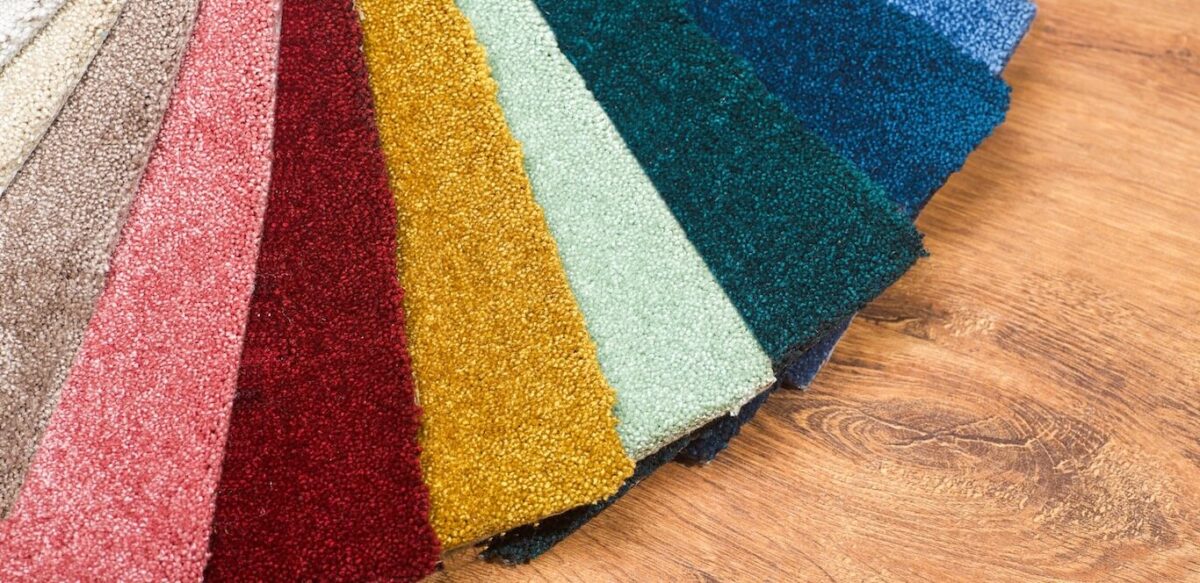 Colorful carpet samples spread out on a floor.